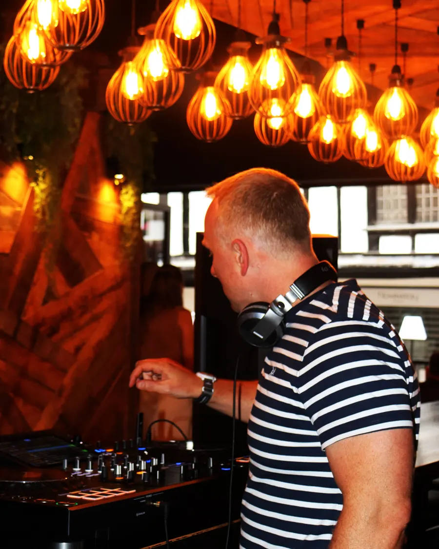 The DJ under the warm bar lights